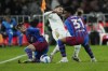 A-Leagues All Stars' Anthony Caceres, centre, battles for the ball with Barcelona's Alex Balde, right, and Barcelona's Gavi during their friendly soccer match at Stadium Australia in Sydney, Australia, Wednesday, May 25, 2022. (AP Photo/Rick Rycroft)