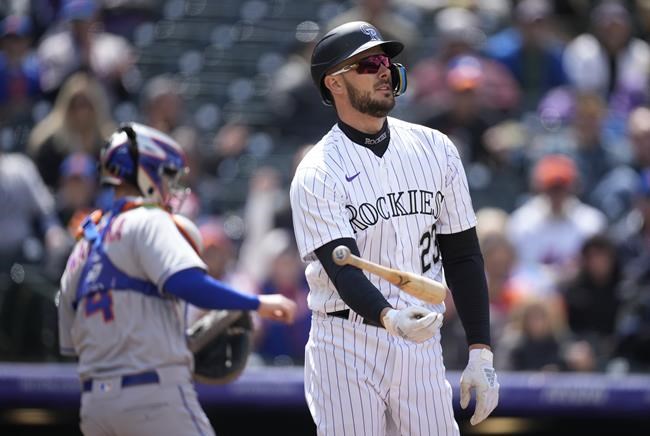 Colorado Rockies' Kris Bryant, right, reacts after being called out on strikes as New York Mets catcher Patrick Mazeika heads to the dugout to end the fifth inning of the first baseball game game of a day/night doubleheader Saturday, May 21 2022, in Denver. (AP Photo/David Zalubowski)