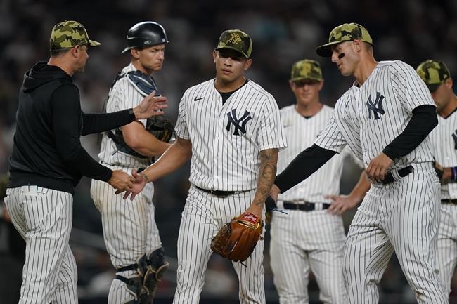New York Yankees relief pitcher Jonathan Loaisiga, center, is relieved after giving up two runs in the eighth inning of the second baseball game of a doubleheader against the Chicago White Sox, Sunday, May 22, 2022, in New York. (AP Photo/John Minchillo)