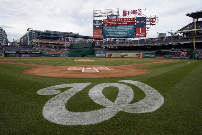 A message on the outfield screen announces the postponement of a baseball game between the Colorado Rockies and the Washington Nationals due to inclement weather, Friday, May 27, 2022, in Washington. The game was rescheduled for Saturday. (AP Photo/Patrick Semansky)