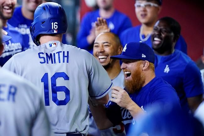 Los Angeles Dodgers' Will Smith (16) celebrates his home run against the Arizona Diamondbacks with teammates, including Justin Turner, front right, and Mookie Betts, middle, during the second inning of a baseball game Sunday, May 29, 2022, in Phoenix. (AP Photo/Ross D. Franklin)