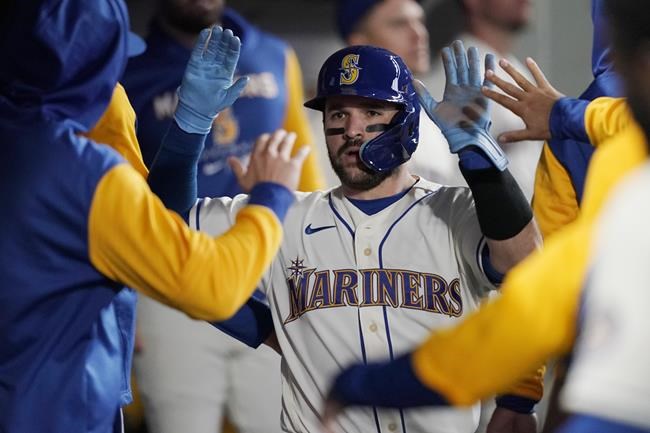 Seattle Mariners' Luis Torrens is greeted in the dugout after he slid safely home to score on a RBI single hit by Ty France during the sixth inning of a baseball game against the Houston Astros, Sunday, May 29, 2022, in Seattle. (AP Photo/Ted S. Warren)