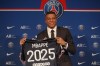 PSG striker Kylian Mbappe shows his jersey during a press conference Monday, May 23, 2022 at the Paris des Princes stadium in Paris. Kylian Mbappé's decision to reject Real Madrid and commit to Paris Saint-Germain for three more seasons marks the start of a large rebuilding project at the French league champion. (AP Photo/Michel Spingler)
