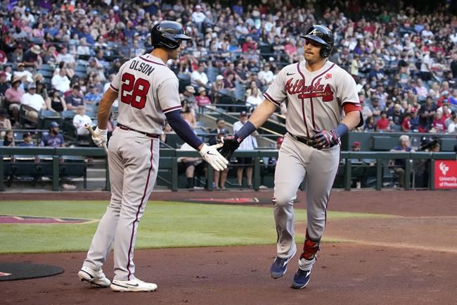 Atlanta Braves' Austin Riley, right, celebrates with Matt Olson (28) after hitting a solo home run against the Arizona Diamondbacks in the fourth inning during a baseball game, Monday, May 30, 2022, in Phoenix. (AP Photo/Rick Scuteri)