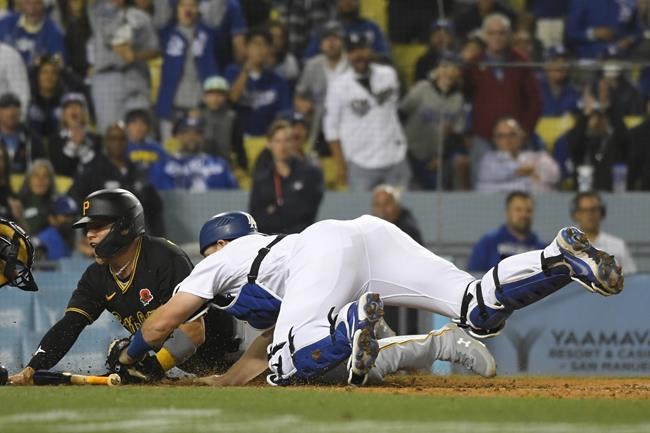 Pittsburgh Pirates Diego Castillo is safe at home as Los Angeles Dodgers catcher Will Smith does not tag him in time during the ninth inning of a baseball game Monday, May 30, 2022, in Los Angeles. (AP Photo/John McCoy)