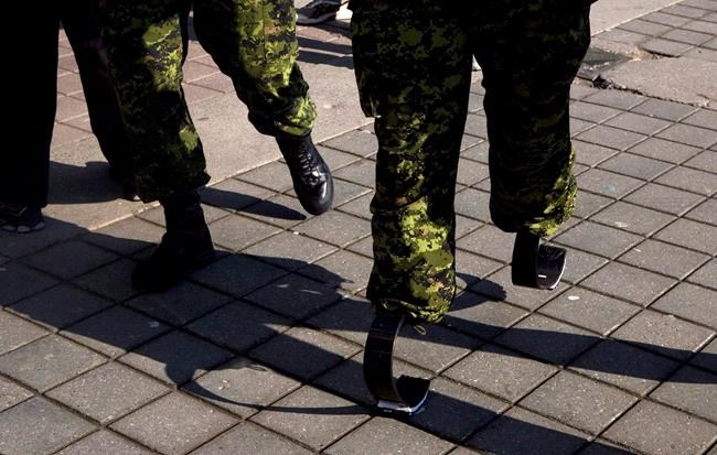 Master Corporal Jody Mitic walks, on his 'running legs' past a fellow soldier, as he prepares for a charity run in Toronto in this March 15, 2009 photo. Canada's auditor general has released a report on wait times for veterans to receive disability benefits. THE CANADIAN PRESS/Chris Young