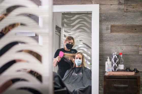 Nikki Tardi does Erica Halmarson's hair at Élan Hair Studio, where they will be keeping a mandatory mask policy. (Mikaela MacKenzie / Winnipeg Free Press)