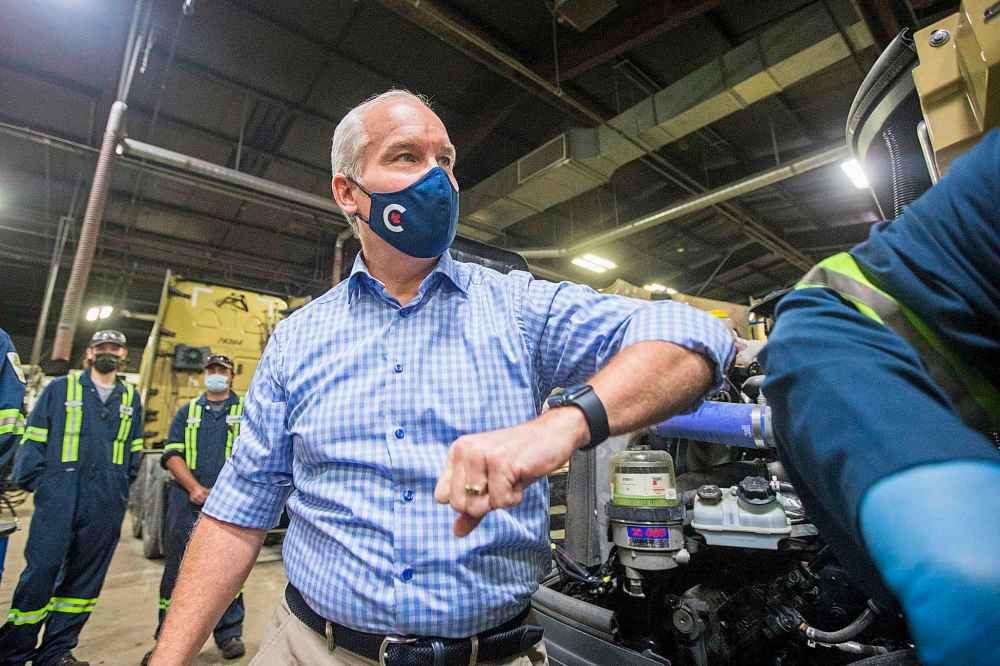 MIKAELA MACKENZIE / WINNIPEG FREE PRESS
Conservative leader Erin O’Toole elbow-bumps a mechanic after learning how to the check the oil on a truck at Bison Transport in Winnipeg on Friday.
