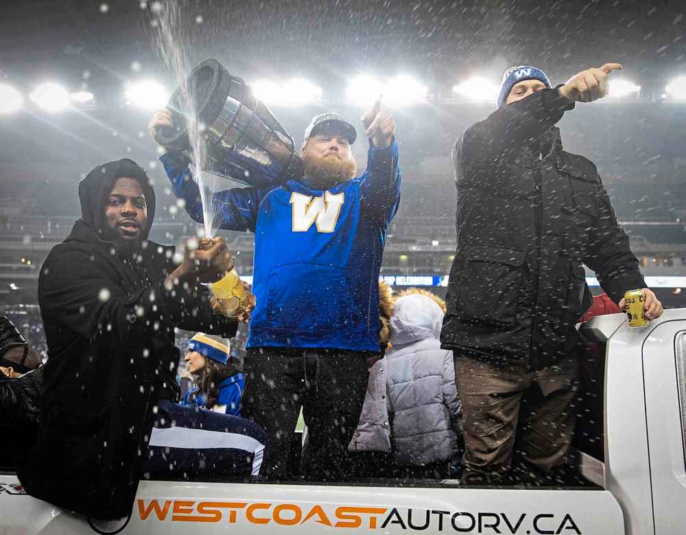 JESSICA LEE / WINNIPEG FREE PRESS
Left to right: Blue Bombers players Stanley Bryant, Chris Kolankowski and Patrick Neufeld celebrate their Grey Cup victory at IG Field Wednesday.