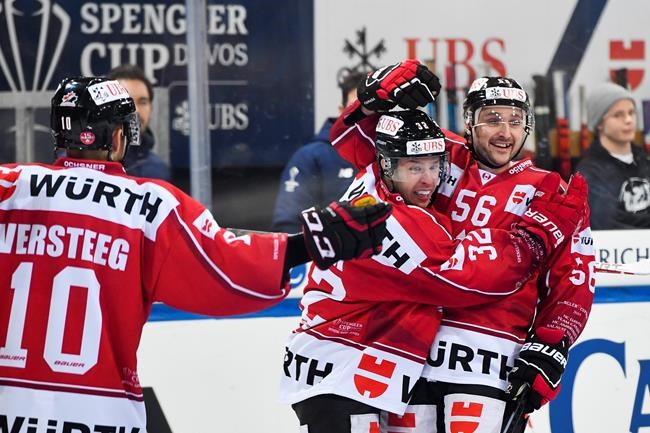 Team Canada's Kevin Clark, center, celebrates after scoring his side opening goal with Team Canada's Maxim Noreau, right, during the game between Team Canada and TPS Turku, at the 93th Spengler Cup ice hockey tournament in Davos, Switzerland, Monday, Dec. 30, 2019. (Gian Ehrenzeller/Keystone via AP)