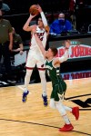 Miami Heat guard Tyler Herro (14) attempts a 3-point basket as Milwaukee Bucks guard Donte DiVincenzo (0) defends during the first half of an NBA basketball game Wednesday, Dec. 30, 2020, in Miami. (AP Photo/Lynne Sladky)