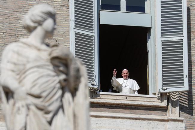 Pope Francis waves briefly from his window overlooking St. Peter's Square after delivering the Angelus prayer on a giant screen in St. Peter's Square aimed at discouraging crowds, at the Vatican, Sunday, March 8, 2020. The pope in his streamed remarks said he was close in prayers to those suffering from the virus and to those caring for them. (AP Photo/Andrew Medichini)