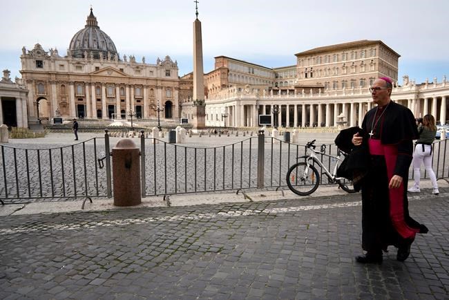 A prelate walks outside St. Peter's Square after the Vatican erected a new barricade at the edge of the square, in Rome, Tuesday, March 10, 2020. Italy entered its first day under a nationwide lockdown after a government decree extended restrictions on movement from the hard-hit north to the rest of the country to prevent the spreading of coronavirus. (AP Photo/Andrew Medichini)