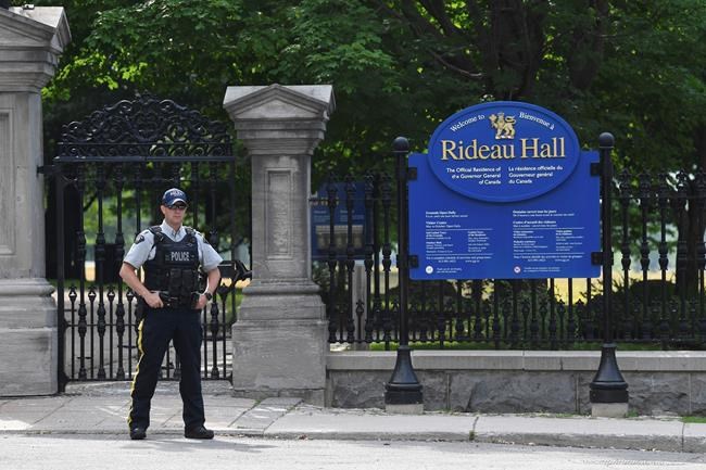 A police officer stands by a fence outside Rideau Hall in Ottawa on Thursday, July 2, 2020. The RCMP say they have safely resolved an
