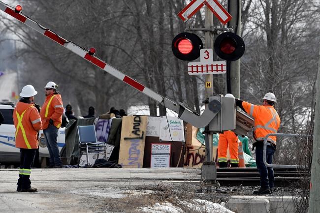 CN Railway workers check the railroad crossing gate as they prepare to resume service after Ontario Provincial Police made arrests at a rail blockade in Tyendinaga Mohawk Territory, near Belleville, Ont., on Monday Feb. 24, 2020, during a protest in solidarity with Wet'suwet'en Nation hereditary chiefs attempting to halt construction of a natural gas pipeline on their traditional territories. THE CANADIAN PRESS/Adrian Wyld