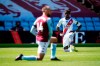 Crystal Palace's Wilfried Zaha takes a knee in support of the Black Lives Matter movement before the English Premier League soccer match between Aston Villa and Crystal Palace at Villa Park in Birmingham, England, Sunday, July 12, 2020. (Tim Keeton/Pool Photo via AP)