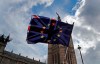 FILE - In this Thursday, April 4, 2019 file photo, a pro EU protestor waves flags opposite the House of Parliament in London. _ Anxious, angry, abandoned. Brexit elicits strong emotions, and as Britain’s departure from the European Union approaches, more than 3 million U.K. residents who are citizens of EU countries feel the impending separation more strongly than most. (AP Photo/Frank Augstein, File)