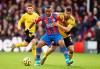 Crystal Palace's Jordan Ayew, foreground, and Arsenal's Sokratis Papastathopoulos battle for the ball, during the English Premier League soccer match between Crystal Palace and Arsenal, at Selhurst Park, in London, Saturday, Jan. 11, 2020. (Tess Derry/PA via AP)