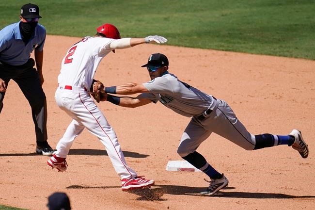 Los Angeles Angels' Andrelton Simmons, front left, is tagged out by Seattle Mariners third baseman Sam Haggerty in a rundown between first and second base during the seventh inning of a baseball game Sunday, Aug. 30, 2020, in Anaheim, Calif. Simmons drove in Albert Pujols with a single on the play. (AP Photo/Marcio Jose Sanchez)