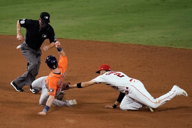 Houston Astros' Kyle Tucker, left, reaches second base with a double ahead of the tag by Los Angeles Angels shortstop Andrelton Simmons during the sixth inning of a baseball game, Friday, Sept. 4, 2020, in Anaheim, Calif. (AP Photo/Jae C. Hong)
