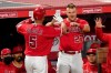 Los Angeles Angels' Albert Pujols, left, is congratulate by Mike Trout after hitting a solo home run during the seventh inning of a baseball game against the Texas Rangers Tuesday, April 20, 2021, in Anaheim, Calif. (AP Photo/Mark J. Terrill)