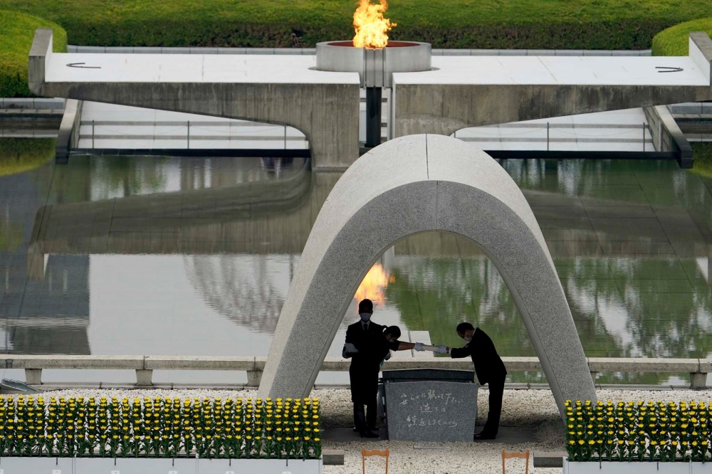 Eugene Hoshiko / The Associated Press
Kazumi Matsui, right, mayor of Hiroshima, and the family of the deceased bow before they place the victims list of the Atomic Bomb at Hiroshima Memorial Cenotaph during the ceremony to mark the 75th anniversary of the bombing at the Hiroshima Peace Memorial Park Thursday.