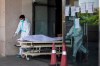 Hospital staff shift the body of a COVID-19 patient on a stretcher to a waiting ambulance at a specialized COVID-19 hospital in Noida, a suburb of New Delhi, India, Wednesday, April 21, 2021. (AP Photo/Altaf Qadri)