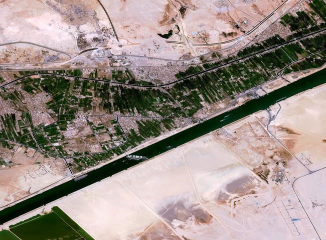 This satellite image from Cnes2021, Distribution Airbus DS, shows the cargo ship MV Ever Given stuck in the Suez Canal near Suez, Egypt, Thursday, March 25, 2021. The skyscraper-sized cargo ship wedged across Egypt's Suez Canal further imperiled global shipping Thursday as at least 150 other vessels needing to pass through the crucial waterway idled waiting for the obstruction to clear, authorities said. (Cnes2021, Distribution Airbus DS via AP)