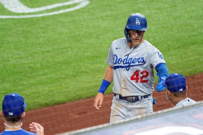 Los Angeles Dodgers' Matt Beaty in congratulated after scoring on a double by A.J. Pollock during the second inning of a baseball game against the Texas Rangers, Saturday, Aug. 29, 2020, in Arlington, Texas. (AP Photo/Jeffrey McWhorter)