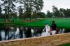 Tony Finau walks across the Sarazen Bridge with his caddie Mark Urbanek on the 15th hole during the third round of the Masters golf tournament on Saturday, April 10, 2021, in Augusta, Ga. (AP Photo/Matt Slocum)