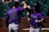 Colorado Rockies' Brendan Rodgers, right, celebrates with C.J. Chron (25) after they both scored off of a home run hit by Rodgers during the first inning of a spring training baseball game against the Arizona Diamondbacks Tuesday, March 9, 2021, in Scottsdale, Ariz. (AP Photo/Ashley Landis)