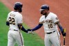 Milwaukee Brewers' Christian Yelich (22) high-fives Omar Narvaez (10) after Yelich hit a home run during the first inning of a spring training baseball game against the Los Angeles Dodgers Tuesday, March 23, 2021, in Phoenix, Ariz. (AP Photo/Ashley Landis)