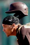 San Diego Padres' Josh Naylor looses his helmet as he advances safely to second base on a fly out by Manny Machado during the third inning of a spring training baseball game against the Kansas City Royals Monday, Feb. 24, 2020, in Surprise, Ariz. (AP Photo/Charlie Riedel)