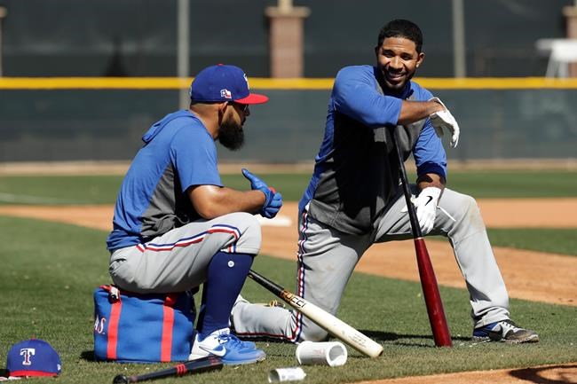 Texas Rangers' Rougned Odor, left, and Elvis Andrus talk while waiting to bat during spring training baseball practice Monday, Feb. 17, 2020, in Surprise, Ariz. (AP Photo/Charlie Riedel)
