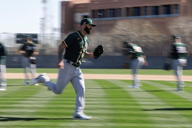 Oakland Athletics' Mike Fiers runs a drill during spring training baseball practice, Thursday, Feb. 13, 2020, in Mesa, Ariz. (AP Photo/Darron Cummings)