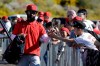 Los Angeles Angels' Brian Goodwin, left, greets a fan during spring training baseball practice, Monday, Feb. 17, 2020, in Tempe, Ariz. (AP Photo/Darron Cummings)