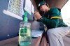 Oakland Athletics minor league manager Scott Steinmann fills-out a line-up in the MLB team's dugout next to a bottle of hand sanitizer before a spring training baseball game against the Seattle Mariners Saturday, March 7, 2020, in Peoria, Ariz. (AP Photo/Elaine Thompson)