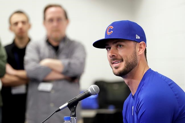 Chicago Cubs third baseman Kris Bryant, right, speaks to reporters during spring training baseball Saturday, Feb. 15, 2020, in Mesa, Ariz. (AP Photo/Gregory Bull)