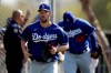 Los Angeles Dodgers pitcher Clayton Kershaw, left, leads pitcher Brusdar Graterol, right, as they head towards the batting cages during spring training baseball Friday, Feb. 21, 2020, in Phoenix. (AP Photo/Gregory Bull)