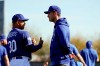Los Angeles Dodgers manager Dave Roberts, left, talks with center fielder Cody Bellinger during spring training baseball Friday, Feb. 14, 2020, in Phoenix. (AP Photo/Gregory Bull)