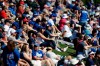 Fans watch from grass beyond the outfield as the Chicago Cubs play the Milwaukee Brewers in a spring training baseball game Saturday, Feb. 29, 2020, in Mesa, Ariz. (AP Photo/Gregory Bull)