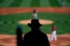 An usher is silhouetted while watching a spring baseball game between the Arizona Diamondbacks and the Milwaukee Brewers in Scottsdale, Ariz., Monday, March 1, 2021. (AP Photo/Jae C. Hong)