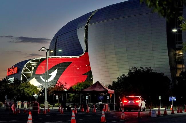 A voter drops off their ballot on Election Day outside State Farm Stadium early, Tuesday, Nov. 3, 2020, in Glendale, Ariz. (AP Photo/Matt York)