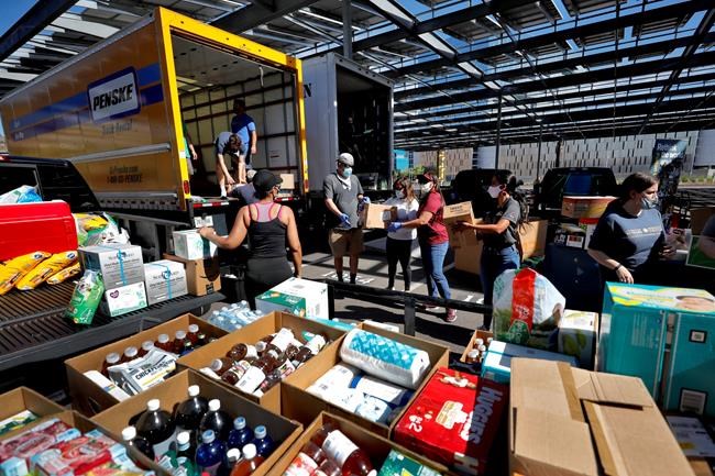 Volunteers prepare donations for delivery to those affected by COVID-19 on tribal lands Thursday, June 25, 2020, in Tempe, Ariz. The resource drive is for families isolated due to COVID-19 on Navajo, Hualapai, Havasupai and White Mountain Apache tribal lands. (AP Photo/Matt York)