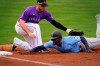 Seattle Mariners' Taylor Trammell dives back safely on a pick-off attempt as Colorado Rockies' C.J. Cron apples the tag during the second inning of a spring training baseball game, Saturday, March 13, 2021, in Scottsdale, Ariz. (AP Photo/Matt York)
