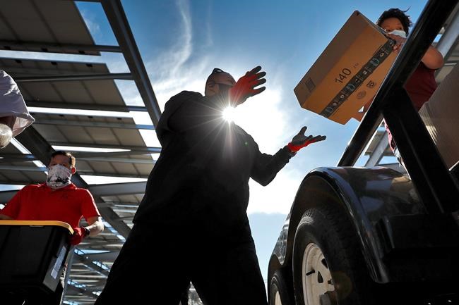 Volunteers prepare donations for delivery to those affected by COVID-19 on tribal lands Thursday, June 25, 2020, in Tempe, Ariz. The resource drive is for families isolated due to COVID-19 on Navajo, Hualapai, Havasupai and White Mountain Apache tribal lands. (AP Photo/Matt York)
