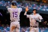 Colorado Rockies' Trevor Story (27) and Raimel Tapia (15) high five after scoring on a base hit by Ryan McMahon during the fourth inning of a baseball game against the Arizona Diamondbacks, Saturday, May 1, 2021, in Phoenix. (AP Photo/Matt York)