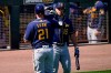 Milwaukee Brewers' Travis Shaw (21) high fives teammate Tyrone Taylor (15) after hitting a solo home run during the first inning of a spring training baseball game against the Oakland Athletics, Wednesday, March 10, 2021, in Mesa, Ariz. (AP Photo/Matt York)
