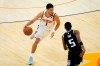 Phoenix Suns guard Devin Booker (1) drives as Sacramento Kings guard De'Aaron Fox (5) defends during the first half of an NBA basketball game, Thursday, April 15, 2021, in Phoenix.(AP Photo/Matt York)