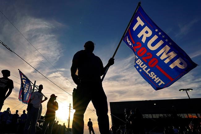 EDS NOTE: OBSCENITY - A Trump supporter stands outside the Maricopa County Recorder's Office, where votes in the general election are being counted, Thursday, Nov. 5, 2020, in Phoenix. (AP Photo/Matt York)